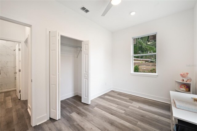 unfurnished bedroom with wood-type flooring, ceiling fan, and a closet