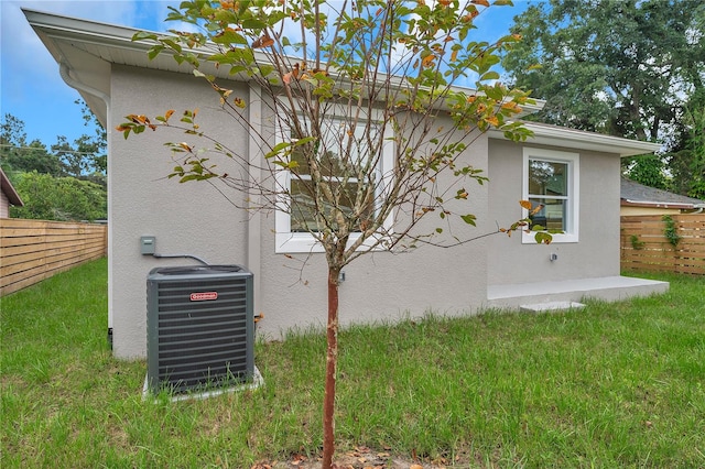 view of property exterior featuring a lawn and central AC unit