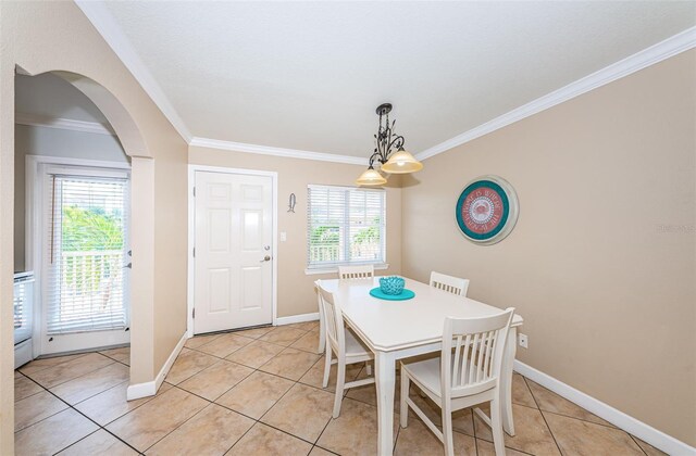 dining area featuring a healthy amount of sunlight, crown molding, and light tile patterned floors