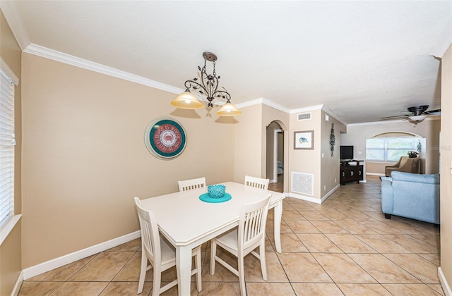 dining area with ceiling fan with notable chandelier, ornamental molding, and light tile patterned floors