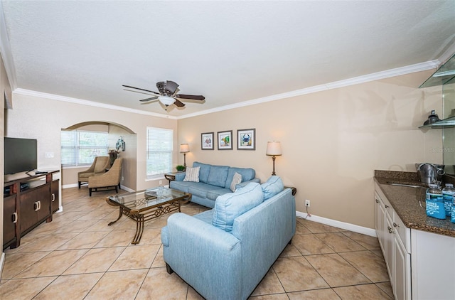 tiled living room featuring ceiling fan, sink, and ornamental molding