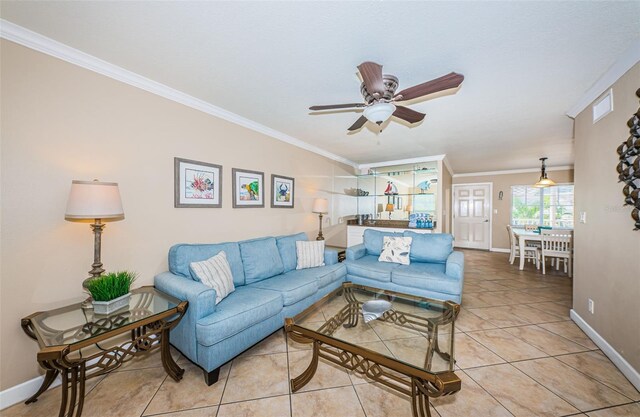 tiled living room featuring ornamental molding and ceiling fan