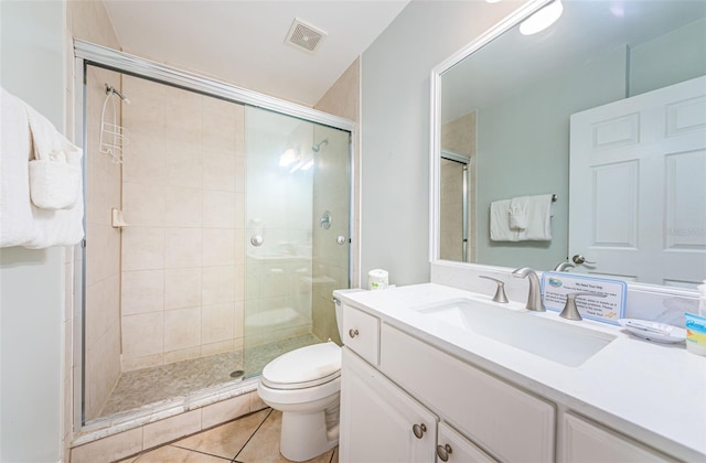 bathroom featuring vanity, toilet, a shower with door, and tile patterned floors