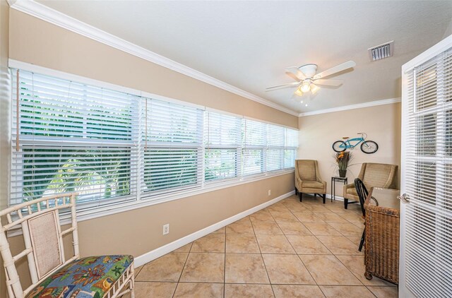 sitting room with ceiling fan, light tile patterned flooring, and crown molding