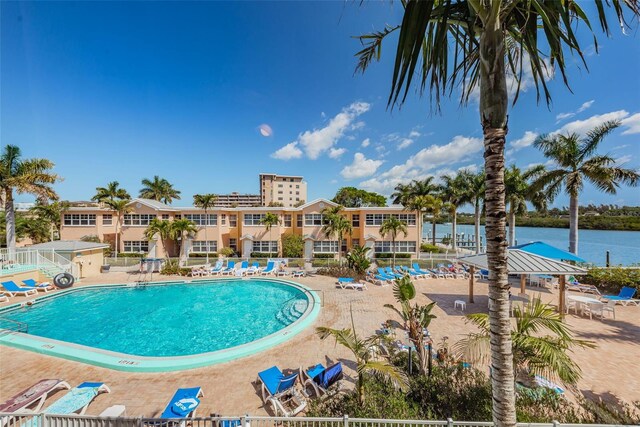 view of swimming pool featuring a water view and a patio area