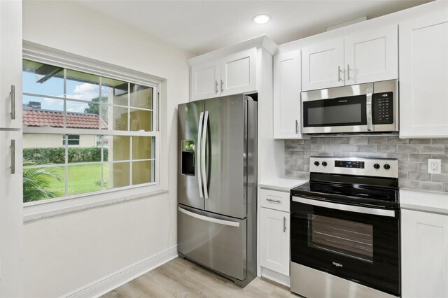 kitchen with tasteful backsplash, stainless steel appliances, and white cabinets