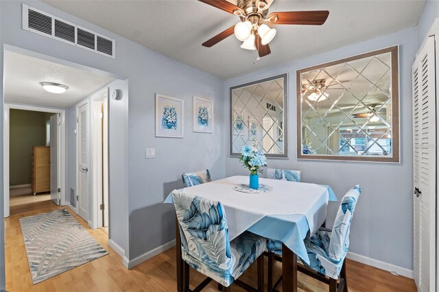 dining area featuring a textured ceiling, light hardwood / wood-style floors, and ceiling fan