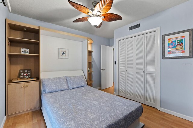 bedroom with ceiling fan, light wood-type flooring, and a closet