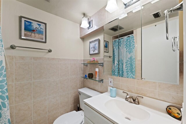 bathroom featuring a shower with curtain, vanity, tile walls, and toilet