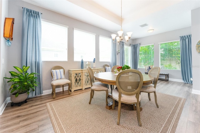 dining space with a notable chandelier, light hardwood / wood-style floors, and a wealth of natural light