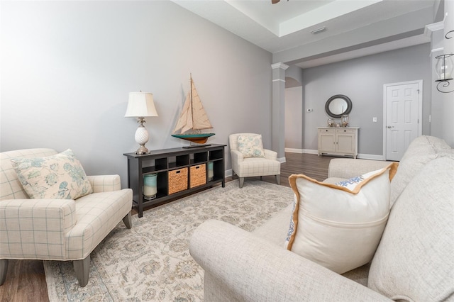 living room featuring ornate columns and hardwood / wood-style floors