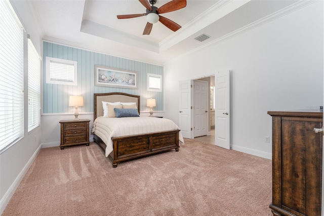 carpeted bedroom featuring ceiling fan, a raised ceiling, and crown molding