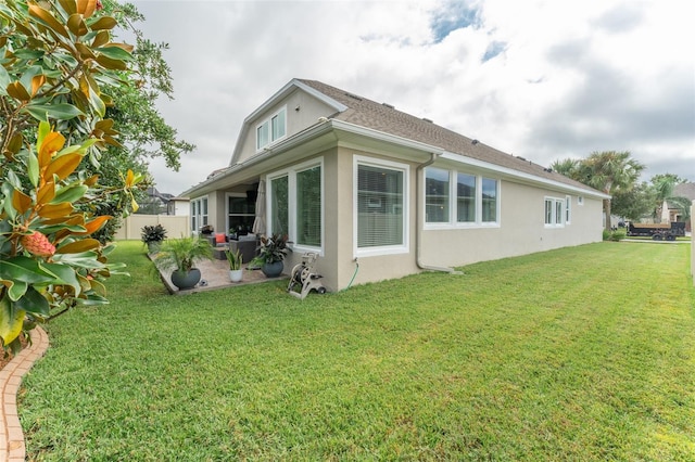 rear view of property featuring a lawn and a patio area