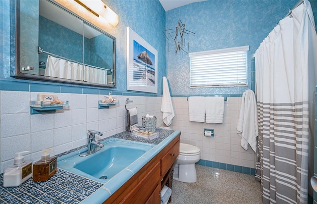 bathroom with a shower with curtain, vanity, tile walls, and toilet