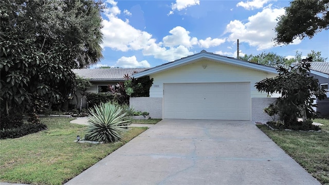 ranch-style home with a garage and a front lawn