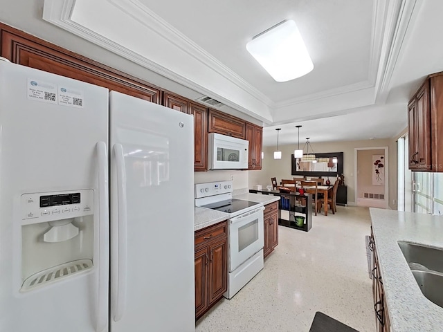 kitchen with white appliances, light stone countertops, a tray ceiling, decorative light fixtures, and ornamental molding