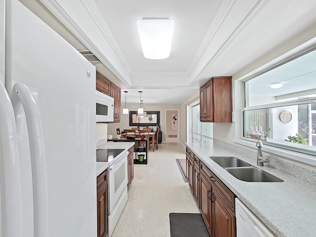 kitchen featuring white appliances, pendant lighting, a tray ceiling, ornamental molding, and sink