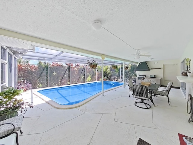 view of swimming pool featuring ceiling fan, glass enclosure, and a patio