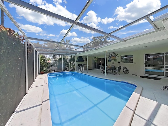 view of swimming pool featuring a lanai and a patio area