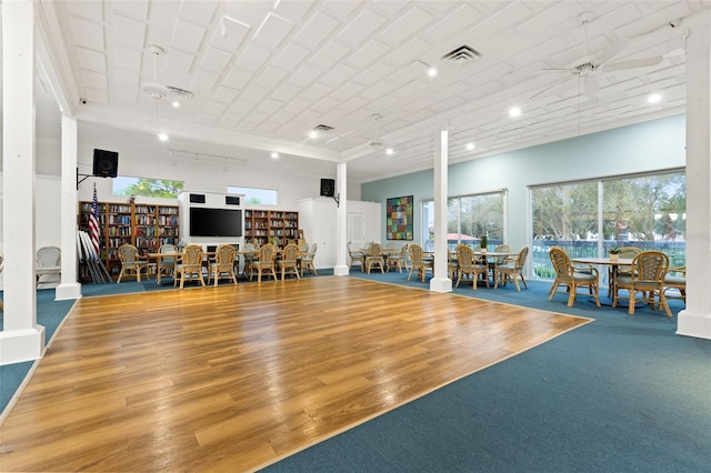 exercise area with decorative columns, ceiling fan, and hardwood / wood-style flooring