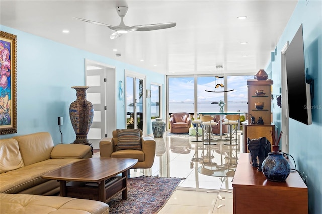 living room with light tile patterned floors, ceiling fan, a wall of windows, and recessed lighting