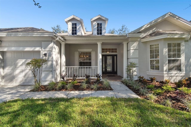 view of front of home with a front lawn, a porch, and a garage