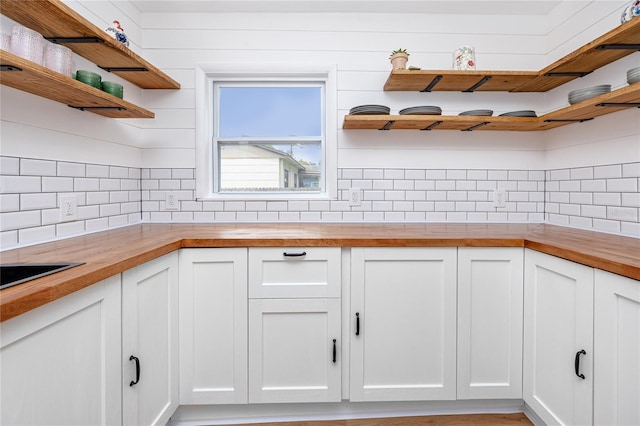 kitchen featuring white cabinets, tasteful backsplash, and wooden counters