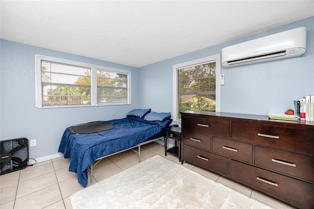 tiled bedroom featuring a textured ceiling and an AC wall unit