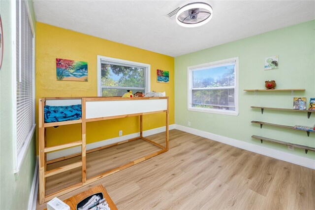 bedroom featuring light hardwood / wood-style floors and multiple windows