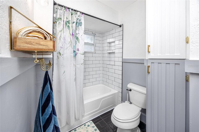 bathroom featuring shower / bath combo with shower curtain, tile patterned floors, and toilet