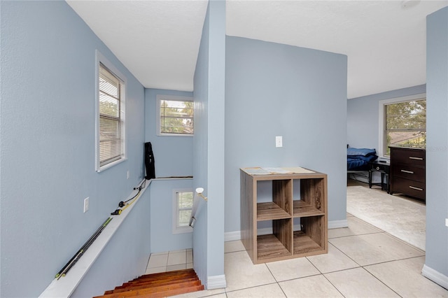 stairway featuring tile patterned flooring and plenty of natural light