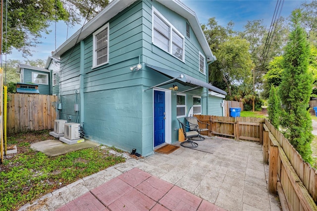 rear view of property featuring ac unit and a patio area