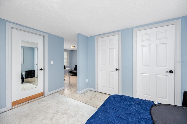 bedroom with a textured ceiling and light tile patterned flooring