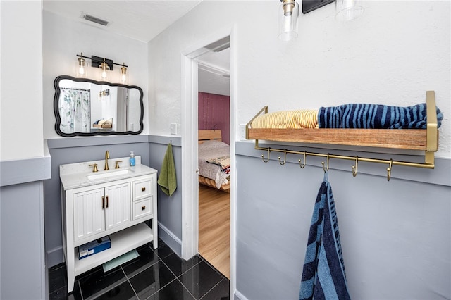 6619 Livingston Ave N, Saint Petersburg, FL 33702 - bathroom featuring visible vents, baseboards, tile patterned floors, vanity, and ensuite bath