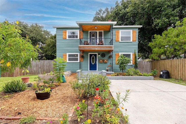 6619 Livingston Ave N, Saint Petersburg, FL 33702 - view of front facade featuring a balcony, a vegetable garden, fence, and concrete driveway