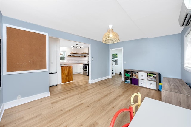6619 Livingston Ave N, Saint Petersburg, FL 33702 - recreation room with baseboards, a wall mounted AC, and light wood-type flooring