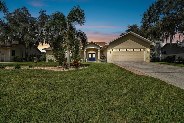 ranch-style house with a yard and a garage