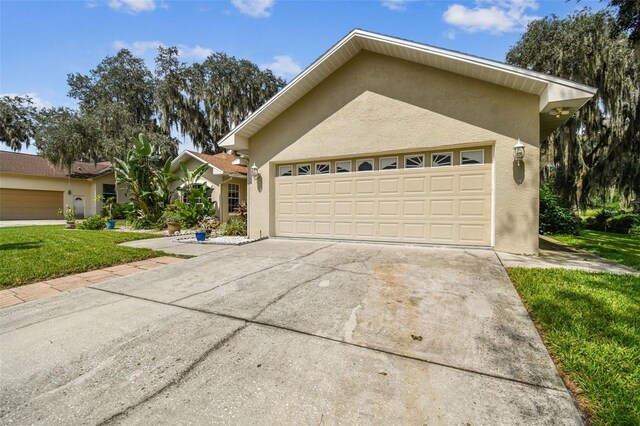 single story home with a garage and a front yard