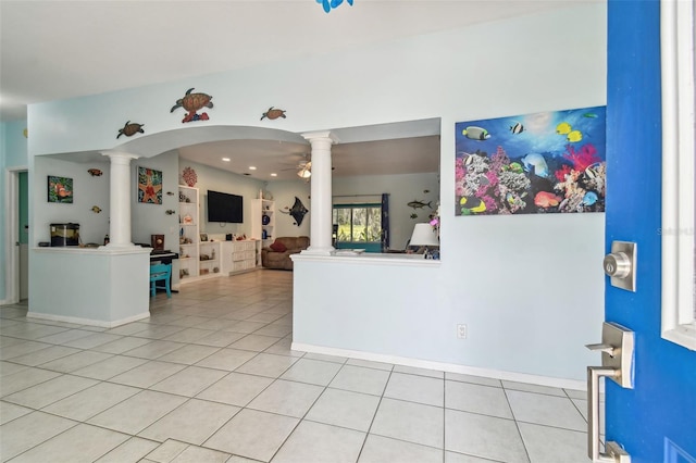 interior space featuring decorative columns, a ceiling fan, and light tile patterned floors