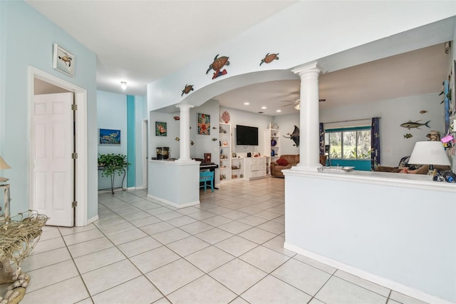 kitchen with decorative columns, light tile patterned floors, open floor plan, and a ceiling fan