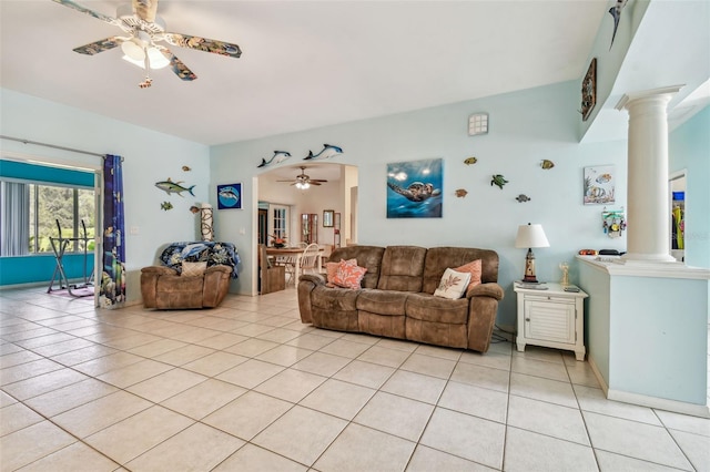 living room featuring ornate columns, light tile patterned flooring, and a ceiling fan