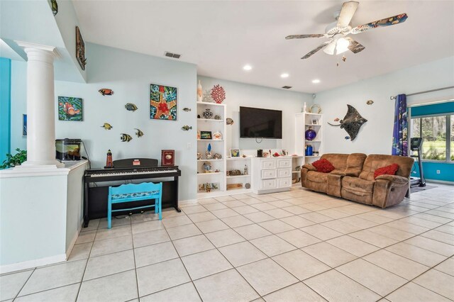 tiled living room featuring ceiling fan and decorative columns