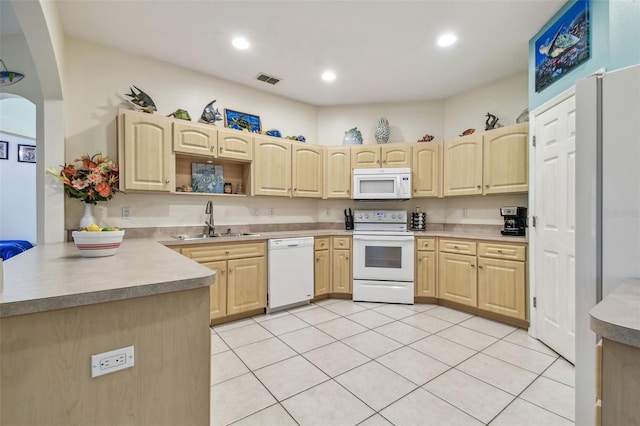 kitchen with white appliances, kitchen peninsula, light tile patterned floors, light brown cabinetry, and sink