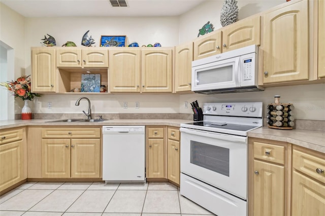 kitchen with light brown cabinets, sink, and white appliances