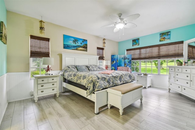 bedroom featuring multiple windows, light hardwood / wood-style floors, and ceiling fan