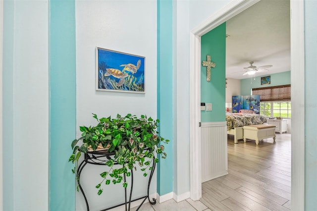 hall featuring wood finished floors and wainscoting