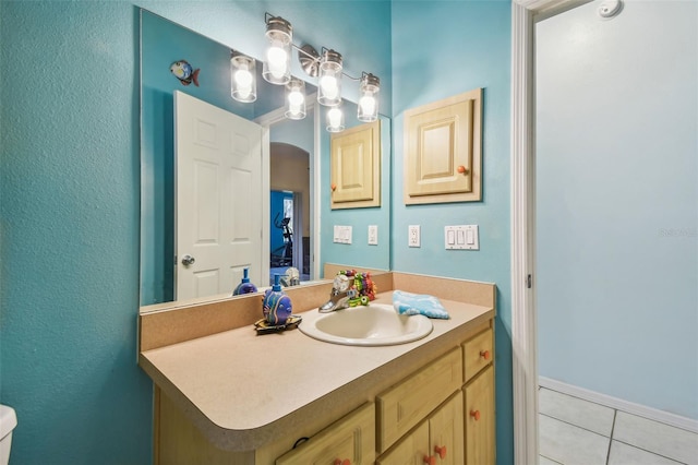 bathroom with vanity, tile patterned flooring, and toilet