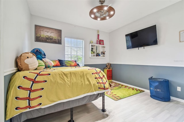 bedroom with baseboards and wood finished floors