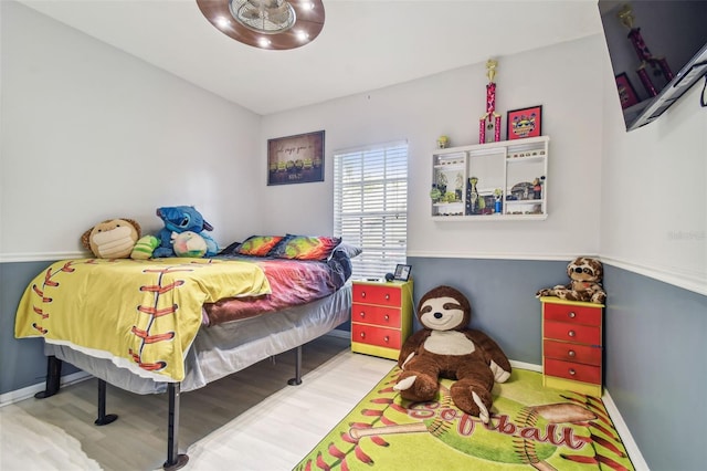 bedroom featuring baseboards and wood finished floors