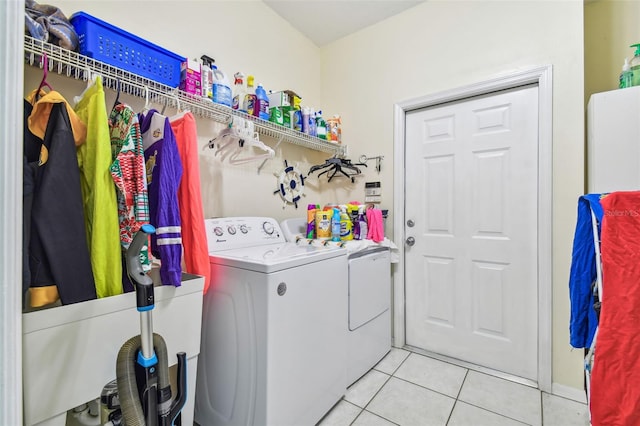 washroom featuring washing machine and clothes dryer, laundry area, and light tile patterned floors